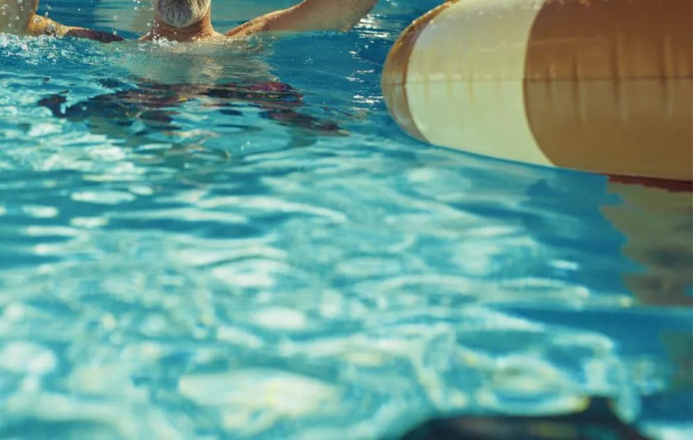 Pool med badande och poolrobot på botten