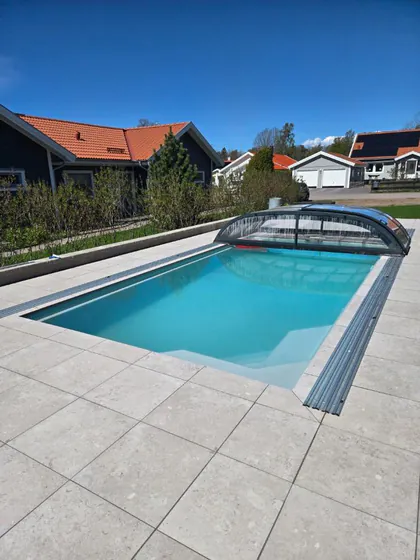 Färdig glasfiberpool med ljusa plattor och pooltak — ett komplett förslag i verkligheten