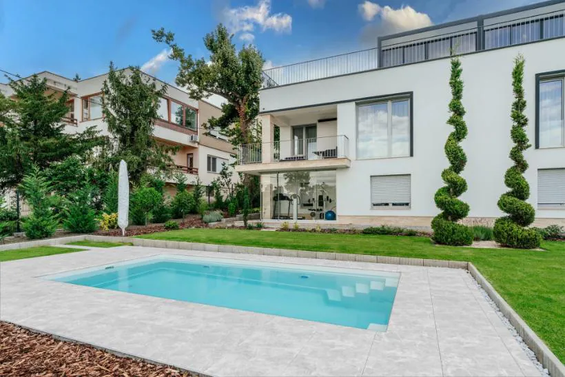 Rektangulär glasfiberpool med vatten i trädgård